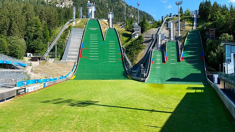 Tagesansicht der Arena in Oberstdorf mit Skisprungschanze im Sommer.