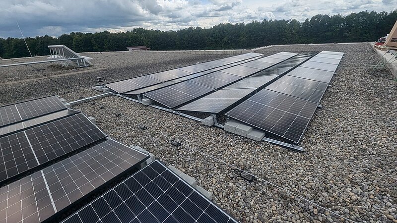 Flachdach des Gymnasiums Buchloe mit montierten Photovoltaikmodulen, Blick über die Dachfläche.