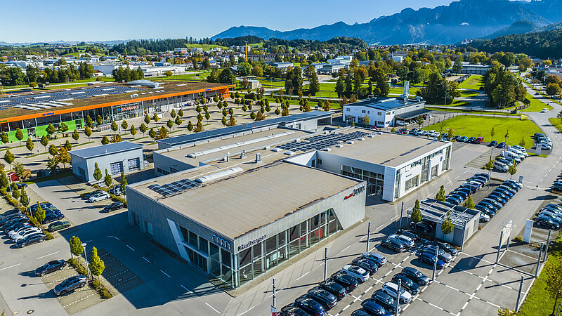 Luftaufnahme vom Autohaus Heuberger in Füssen mit Parkplatz und Autos.