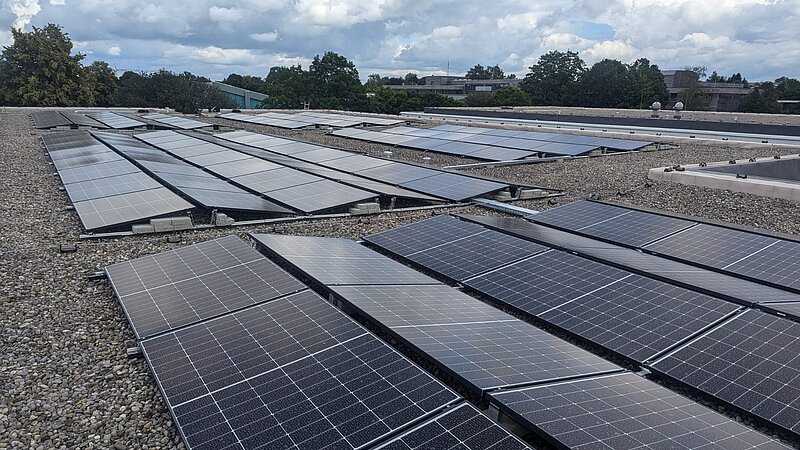 Flachdach des Gymnasiums Buchloe mit montierten Photovoltaikmodulen, Blick über die Dachfläche.