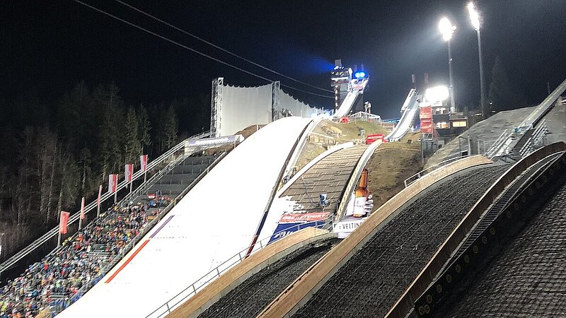 Ansicht der Arena in Oberstdorf mit Skisprungschanze bei Nacht.
