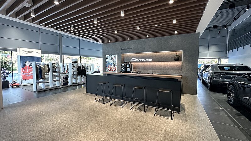 Innenansicht einer Theke für Getränke mit Barhockern des Porsche Zentrum Allgäu in Kempten.