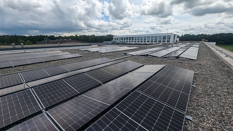 Flachdach des Gymnasiums Buchloe mit montierten Photovoltaikmodulen, Blick über die Dachfläche.