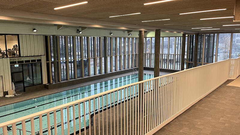 Innenansicht mit Geländer auf ein Schwimmbecken der Therme in Oberstdorf.