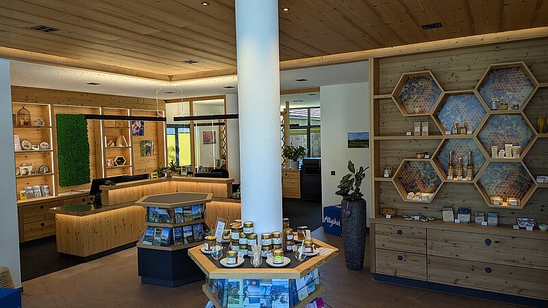 Innenansicht mit Regalen mit Verkaufsartikeln in der Tourist Information der Gemeinde Seeg.
